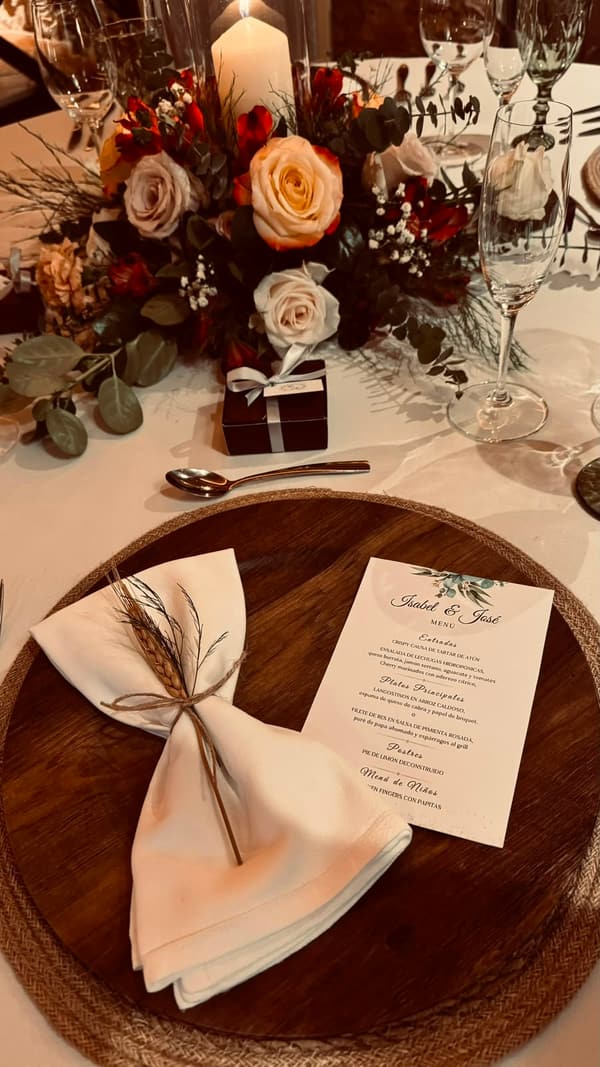 Puesto de mesa con servilleta beige atada con espiga y menú de boda