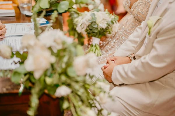 Arreglo de rosas blancas junto a una invitada durante la recepción