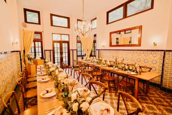 Salón de boda con mesa imperial, camino floral y lámpara de araña