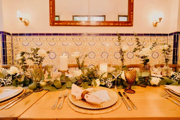 Detalle del camino de mesa con velas, eucalipto y vajilla artesanal