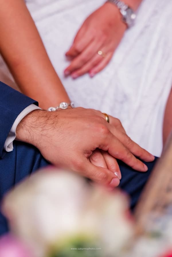 Manos de los novios con las argollas puestas durante la recepción